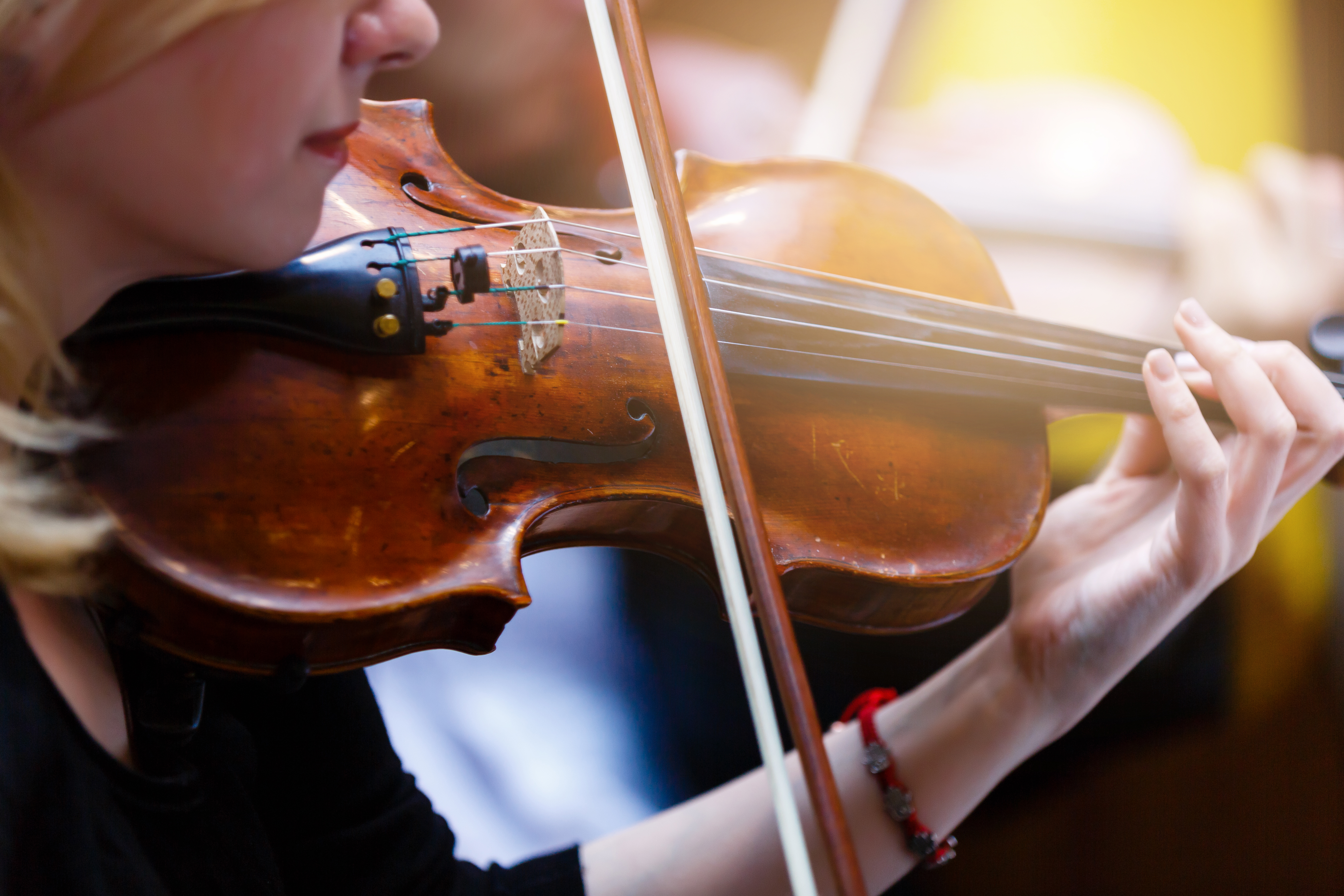 The hand of the girl playing the violin in dark colors